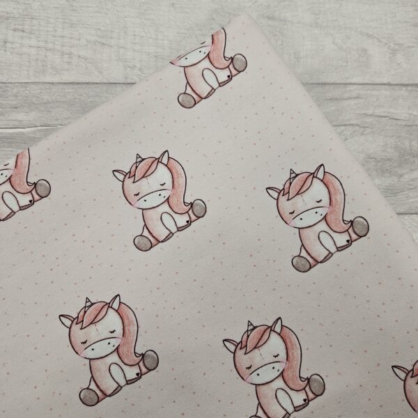 Unicorn Dreams Jersey Fabric is a soft pink baby unicorn design with a repeating image.