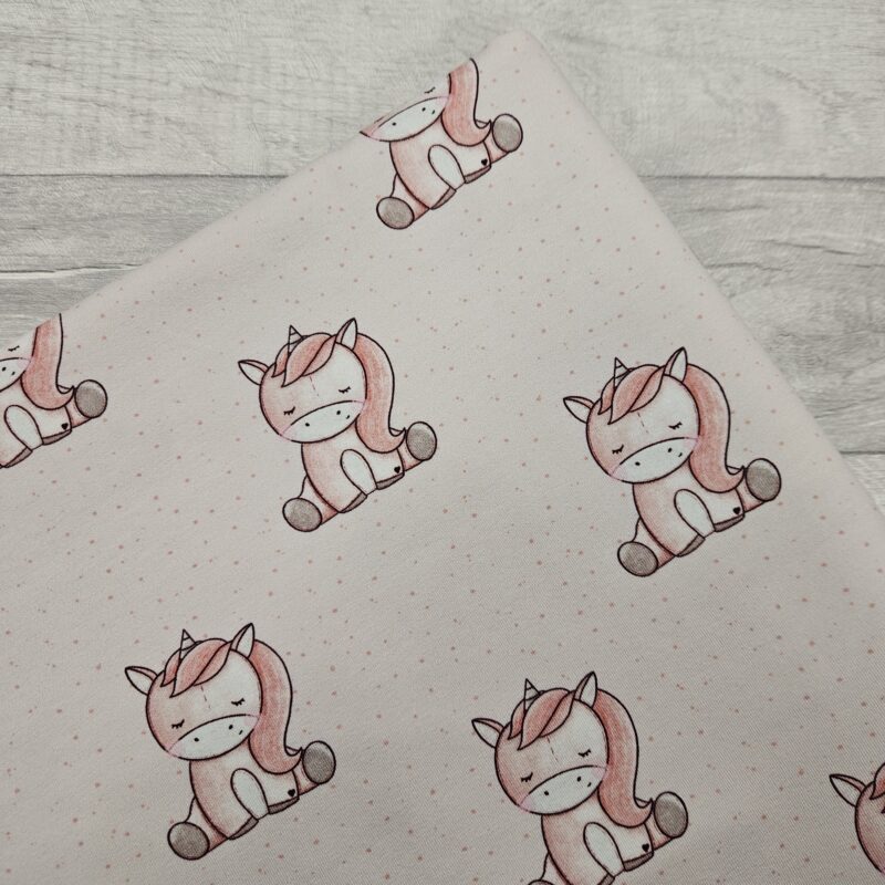 Unicorn Dreams Jersey Fabric is a soft pink baby unicorn design with a repeating image.